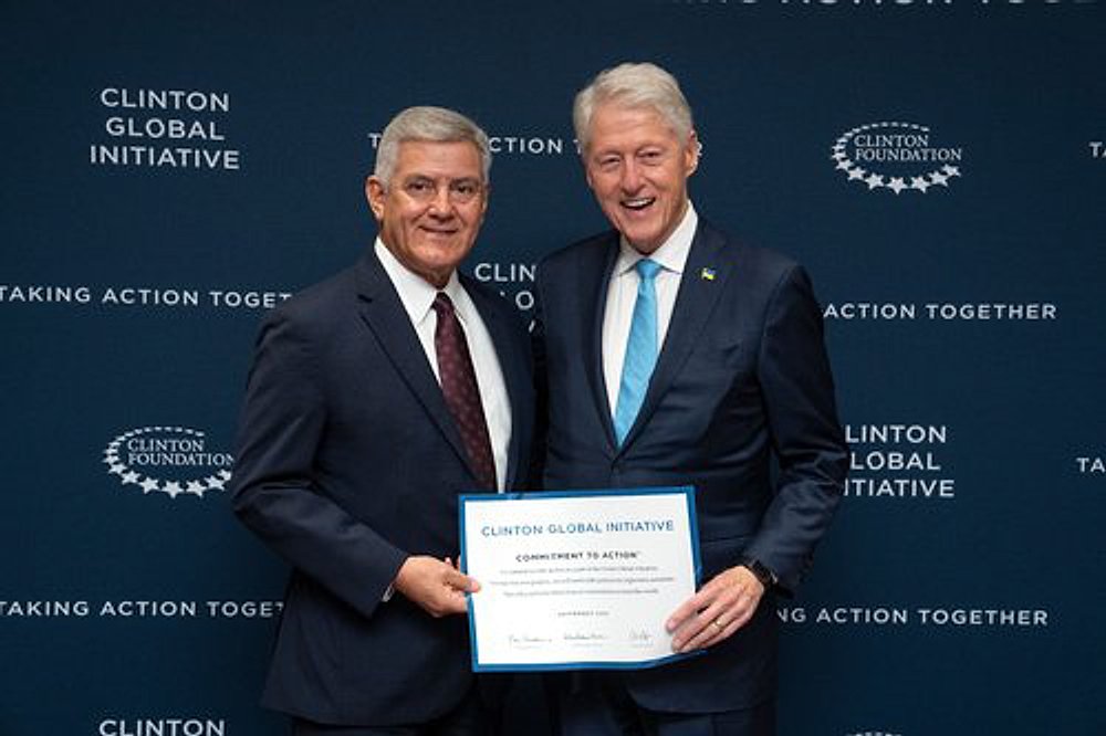 Clinton Global Initiative Commitment to Action certificate presentation with former U.S. President Bill Clinton